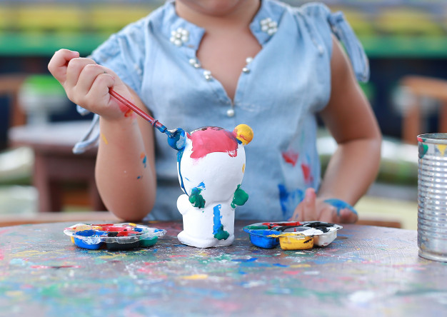 close-up-little-girl-paint-stucco-doll_38678-2815