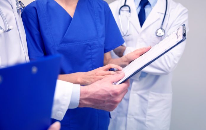 close up of doctors with clipboard at hospital close up of doctors with clipboard at hospital
