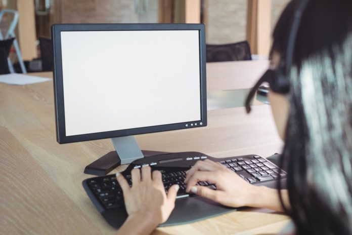 Cropped image of businesswoman working on computer at call center Cropped image of businesswoman working on computer at call center