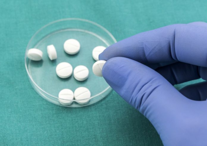 Doctor supports in its hand some white pills Doctor supports in its hand some white pills