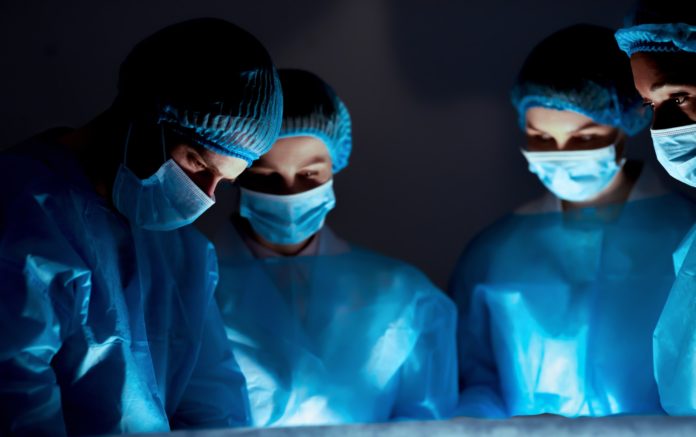 Team of professional surgeons performing surgery in hospital Team of professional surgeons performing surgery in hospital