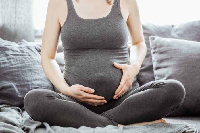 Young pregnant woman touching her belly Young pregnant woman touching her belly