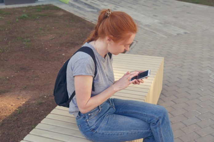young redhair hipster woman using phone.